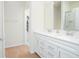 Bright bathroom featuring double sinks with white cabinetry and a view into the walk-in closet at 14250 Lanikai Beach Dr, Orlando, FL 32827