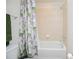 Well-lit bathroom featuring a shower/tub combination with floral curtain and chrome fixtures at 14250 Lanikai Beach Dr, Orlando, FL 32827