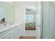 Modern bathroom featuring dual sinks, white cabinets and countertops, tile and glass shower, and bedroom view at 14250 Lanikai Beach Dr, Orlando, FL 32827