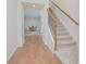 Hallway with wood-look floors leading to dining room and stairway with decorative rod iron handrail at 14250 Lanikai Beach Dr, Orlando, FL 32827