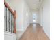 Bright hallway features wood-look tile floors, access to the front door and a staircase with rod iron details at 14250 Lanikai Beach Dr, Orlando, FL 32827