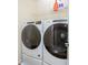 Modern laundry room featuring a white Whirlpool washer and dryer set with wire shelving above at 14250 Lanikai Beach Dr, Orlando, FL 32827