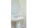 Bright powder room featuring a pedestal sink and oval mirror at 14250 Lanikai Beach Dr, Orlando, FL 32827