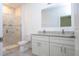 Bathroom featuring a double sink vanity with granite countertops, tile flooring, and a glass-enclosed shower at 14742 Sw 43Rd Terrace Rd, Ocala, FL 34473