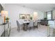 Dining area featuring a modern white table, gray chairs, and view into kitchen and living spaces at 14742 Sw 43Rd Terrace Rd, Ocala, FL 34473