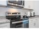 Close up on the kitchen stove, microwave and white cabinets, and granite countertops at 14742 Sw 43Rd Terrace Rd, Ocala, FL 34473