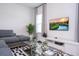 Well-lit living room featuring a gray sofa, stylish rug, modern coffee table, and a flat-screen television at 14742 Sw 43Rd Terrace Rd, Ocala, FL 34473