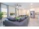 Bright living room featuring a comfortable gray sectional sofa, modern decor, and an open layout connecting to the kitchen at 14742 Sw 43Rd Terrace Rd, Ocala, FL 34473