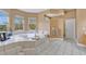 Large bathroom featuring a tiled tub, white tile floors, and large windows at 1601 Billingshurst Ct, Orlando, FL 32825