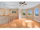 Bright bonus room with hardwood floors, a modern ceiling fan, and a decorative chandelier by the stairs at 1601 Billingshurst Ct, Orlando, FL 32825