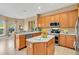 Well-lit kitchen with stainless steel appliances, wooden cabinets, and a central island at 1601 Billingshurst Ct, Orlando, FL 32825