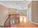 Bright landing area with wood floors, chandelier, and staircase with wooden railings at 1601 Billingshurst Ct, Orlando, FL 32825