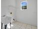 Bright laundry room with a utility sink and tiled floors at 1601 Billingshurst Ct, Orlando, FL 32825