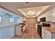 Well-lit kitchen with modern appliances, white cabinets, granite countertops, wood flooring, and view into the living room at 1750 E Welch Rd, Apopka, FL 32712