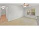 This bedroom has carpet, a ceiling fan, and a view of treed yard and hallway at 2106 Northlake Dr # 2106, Sanford, FL 32773
