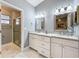 Bright bathroom with a double sink vanity, gray walls, and a glass door shower at 216 Springside Rd, Longwood, FL 32779