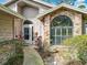 Inviting front entrance with a brick accent wall, a glass front door, and lush landscaping at 216 Springside Rd, Longwood, FL 32779