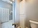 Hallway with a linen closet and a view into a marble tile bathroom with toilet at 216 Springside Rd, Longwood, FL 32779