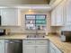 Close-up of a kitchen featuring stainless steel appliances and white cabinets with granite countertops at 216 Springside Rd, Longwood, FL 32779