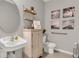 Charming bathroom features a pedestal sink, decorative cabinet, and coastal-themed artwork at 2801 Jamaica Way, Haines City, FL 33844