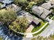 Gorgeous aerial view of a home with solar panels, a screened-in pool, and a brick driveway at 2856 Park Meadow Dr, Apopka, FL 32703