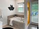 Bathroom featuring a large soaking tub, tile surround, Mickey Mouse decor, and access to the outdoor patio at 2904 Penelope Loop, Kissimmee, FL 34746