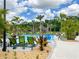 Beautiful community pool area surrounded by palm trees, lounge chairs, and a play structure, creating a resort-like atmosphere at 2904 Penelope Loop, Kissimmee, FL 34746