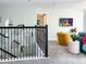 Upstairs hallway with decorative mirrors, black railing, and a view to the lounge area with television at 2904 Penelope Loop, Kissimmee, FL 34746