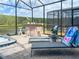 Relaxing screened-in patio features a hot tub, bar, and lounge chairs, perfect for enjoying the outdoors at 2904 Penelope Loop, Kissimmee, FL 34746