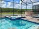 Beautiful pool and spa area in screened in patio with an outdoor bar and lake views at 2904 Penelope Loop, Kissimmee, FL 34746