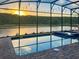 Beautiful sunset reflecting over the pool with an enclosed lanai for outdoor enjoyment at 2904 Penelope Loop, Kissimmee, FL 34746