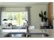 Granite kitchen counter with a stainless steel sink and faucet; a bright living room in background at 3356 Private Oak Dr, Apopka, FL 32703