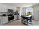 Modern kitchen with white cabinetry, stainless steel appliances, and adjacent breakfast table at 3356 Private Oak Dr, Apopka, FL 32703