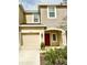 Two-story home featuring neutral stucco, red door, tan garage door, and manicured landscaping at 3587 Davenport Creek Ct, Kissimmee, FL 34746