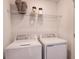 Functional laundry room with modern white washer and dryer and wire shelving at 3587 Davenport Creek Ct, Kissimmee, FL 34746