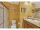 Bright yellow bathroom featuring a shower, toilet, vanity with sink, and decorative framed artwork at 3909 Messina Dr, Lake Mary, FL 32746