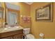 Bright half-bathroom with granite countertops, wood cabinets, and gold walls at 3909 Messina Dr, Lake Mary, FL 32746