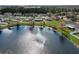 Scenic aerial view of a home backing onto a tranquil lake with a fountain, surrounded by lush landscaping at 4057 Sunny Day Way, Kissimmee, FL 34744