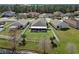 Aerial view of backyard, featuring a screen porch, manicured lawn, and white fence bordering the picturesque lake at 4057 Sunny Day Way, Kissimmee, FL 34744