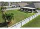 Spacious backyard featuring a well-maintained lawn, white fence, and screened lanai, perfect for outdoor entertaining at 4057 Sunny Day Way, Kissimmee, FL 34744