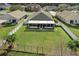 Aerial view of a home's expansive backyard with a well-maintained lawn, screened porch, and white perimeter fence at 4057 Sunny Day Way, Kissimmee, FL 34744