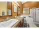 Bathroom featuring double sinks with a stone counter and tiled shower and tub at 4057 Sunny Day Way, Kissimmee, FL 34744