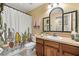 Charming bathroom featuring a decorative mirror and shower with a playful cactus-themed curtain at 4057 Sunny Day Way, Kissimmee, FL 34744