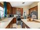 Well-lit kitchen showcasing stainless steel appliances and plentiful wooden cabinets and countertops at 4057 Sunny Day Way, Kissimmee, FL 34744