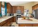 Well-lit kitchen with modern appliances, wood cabinetry, kitchen island, and tile backsplash at 4057 Sunny Day Way, Kissimmee, FL 34744