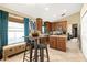 Well-lit kitchen with modern appliances, wood cabinetry, kitchen island, and views to dining room at 4057 Sunny Day Way, Kissimmee, FL 34744