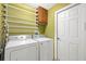 Laundry room with a washer, dryer, hanging rack, and an upper cabinet at 4057 Sunny Day Way, Kissimmee, FL 34744