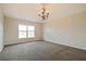 Bedroom with carpet, window, and a decorative light fixture at 4191 Sw 110Th Ln, Ocala, FL 34476