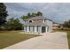 Home exterior with a concrete driveway, manicured lawn, and dark shutters providing contrast against the home's siding at 4191 Sw 110Th Ln, Ocala, FL 34476