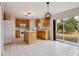 Bright kitchen featuring an island, tile flooring, wood cabinets, and sliding doors leading to the backyard at 4191 Sw 110Th Ln, Ocala, FL 34476